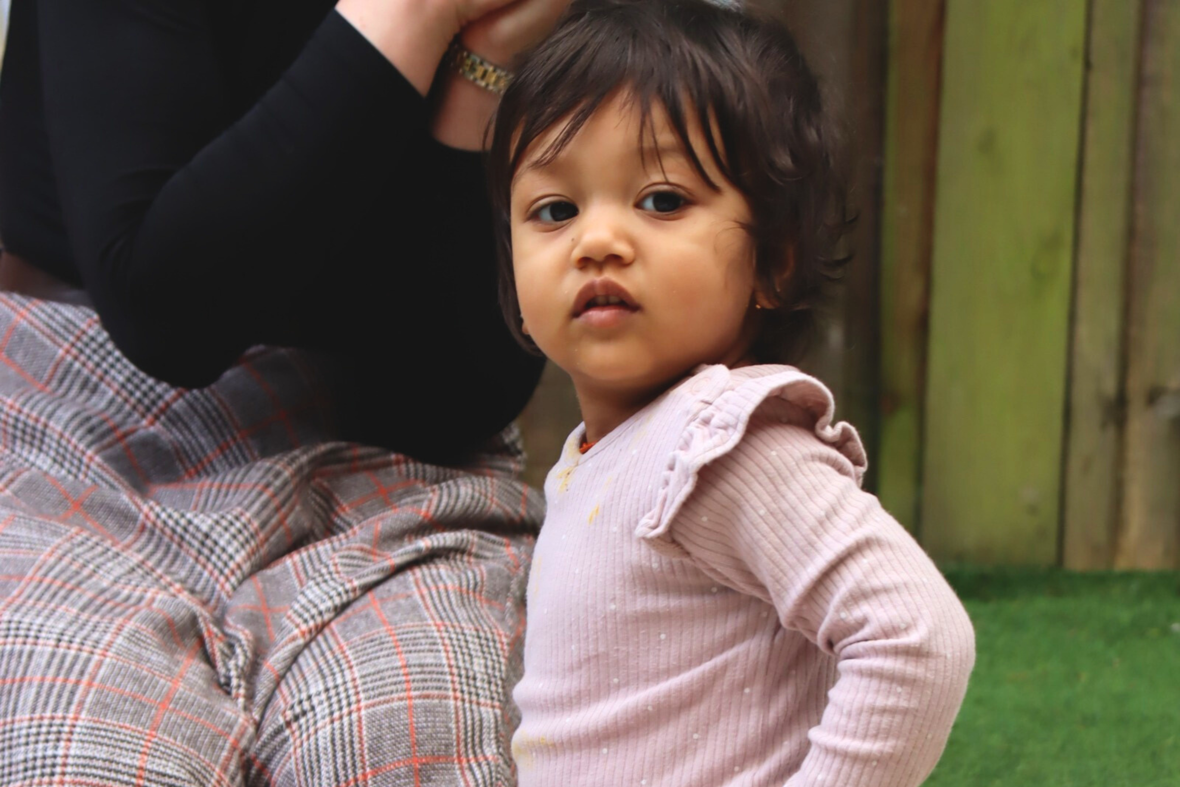 one of Budding Learners babies smiling to one of the Baby room's teachers